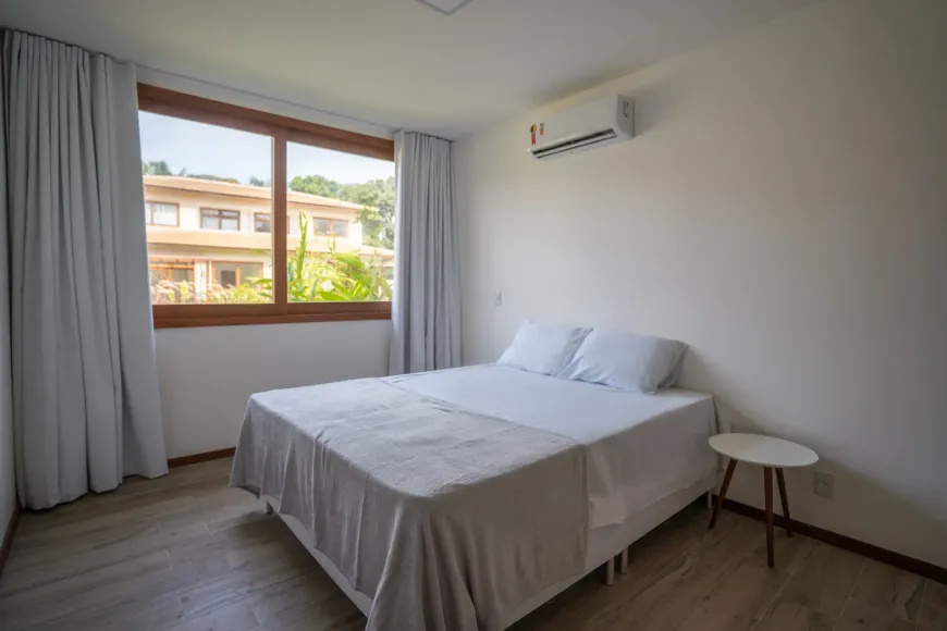 Quarto com cama de casal arrumada e ar-condicionado